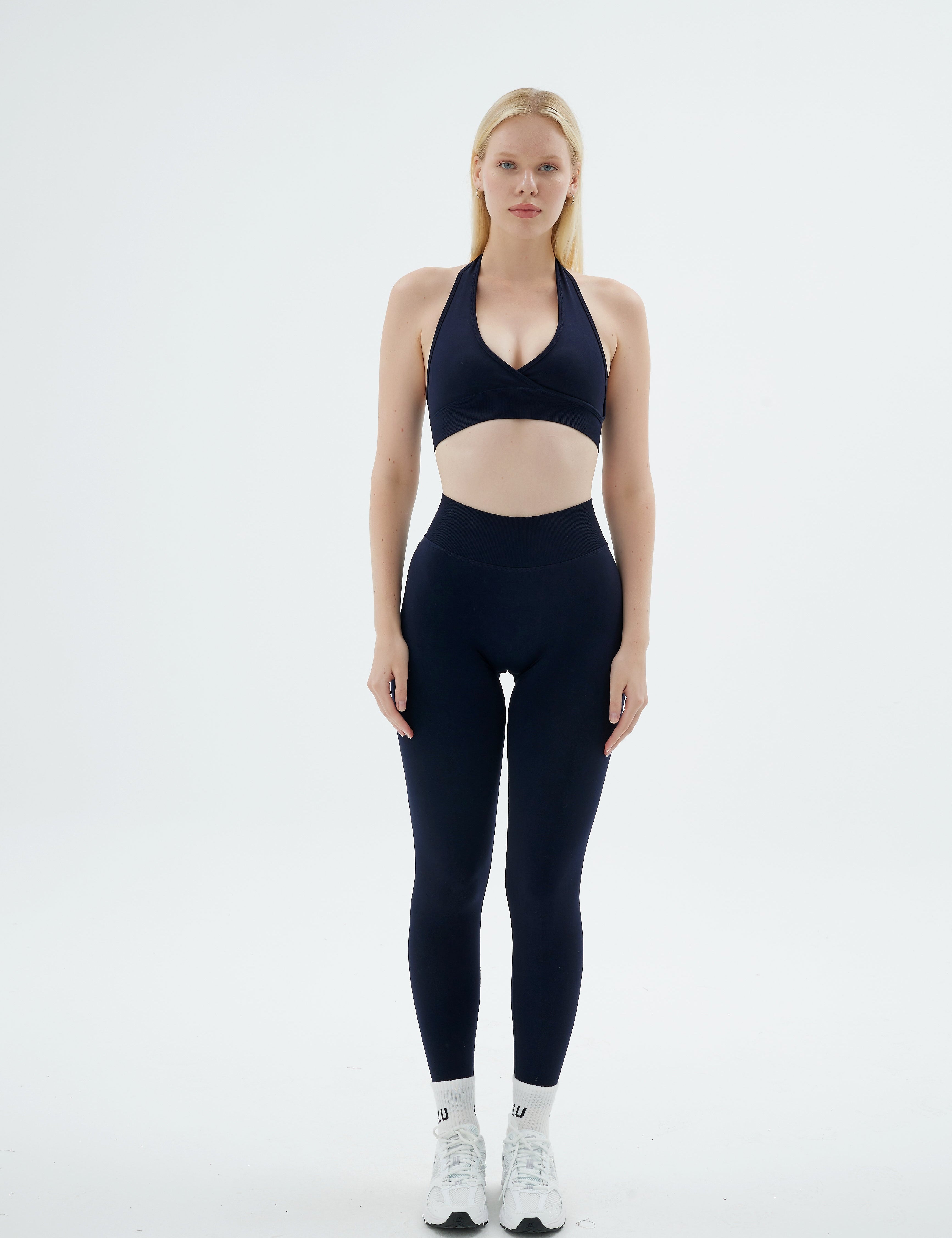 Lacivert Rise Scrunch Pro tayt ve Rise Crossline Bra takımı giymiş kadın