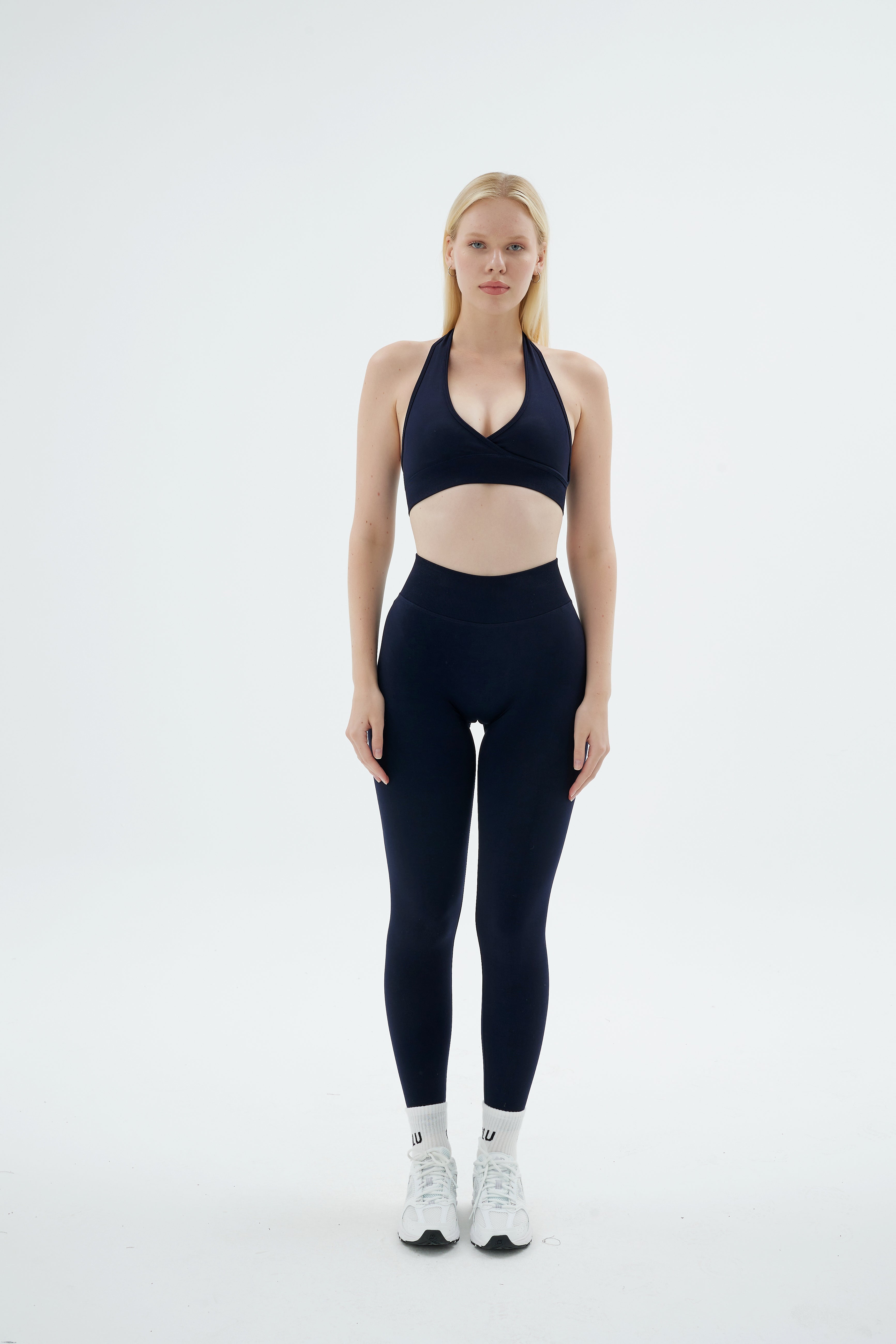 Lacivert Rise Scrunch Pro tayt ve Rise Crossline Bra takımı giymiş kadın