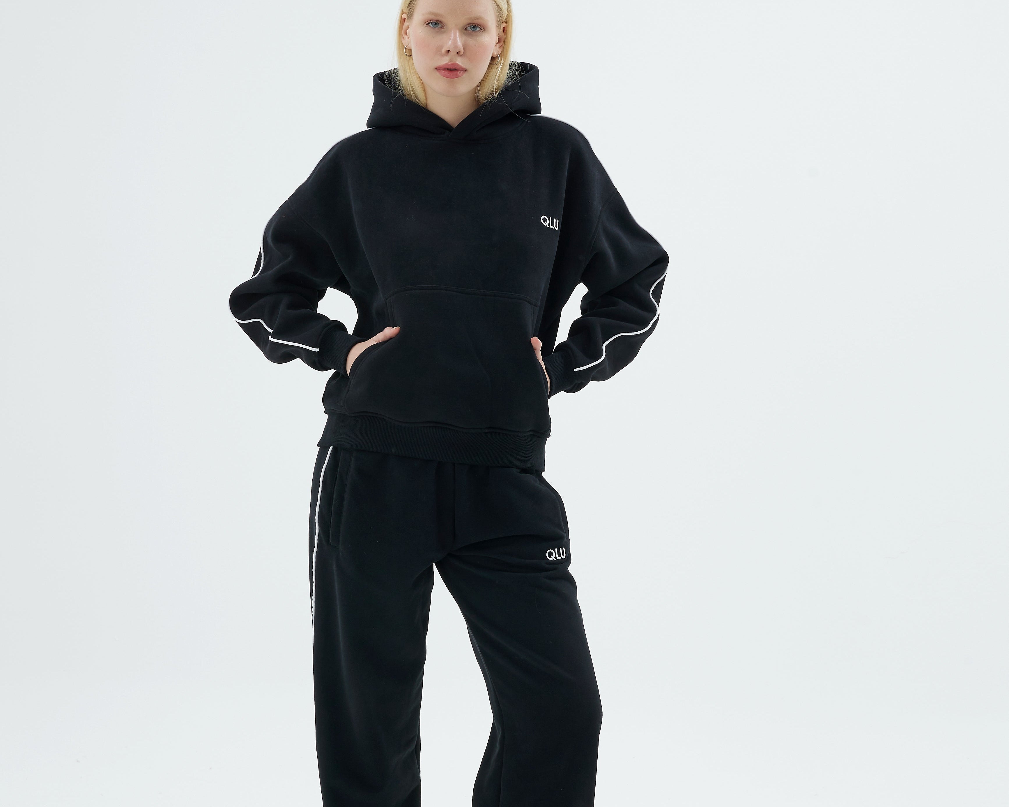 Siyah QLU Rise Line hoodie ve Line jogger eşofman takımı giymiş kadın