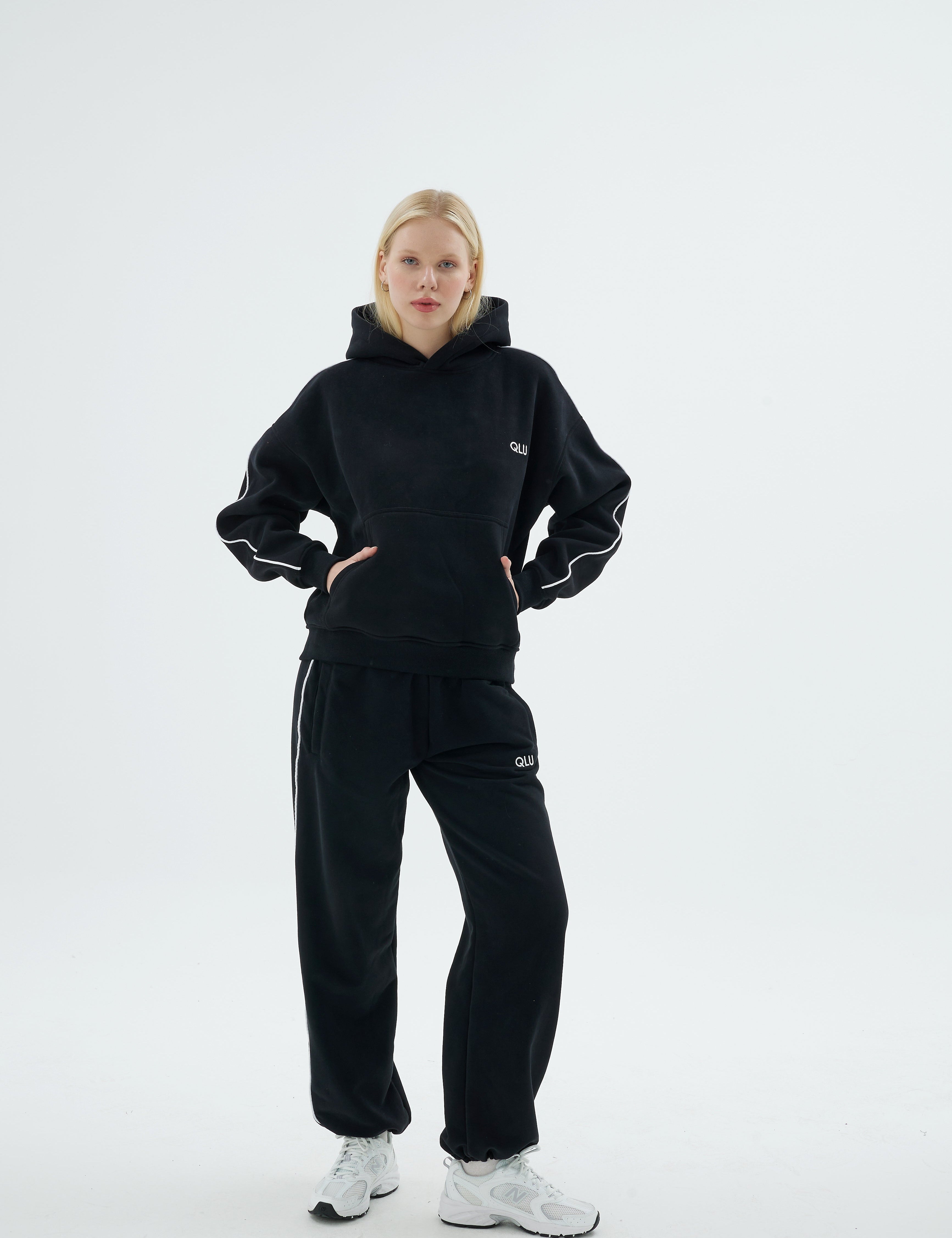 Siyah QLU Rise Line hoodie ve Line jogger eşofman takımı giymiş kadın