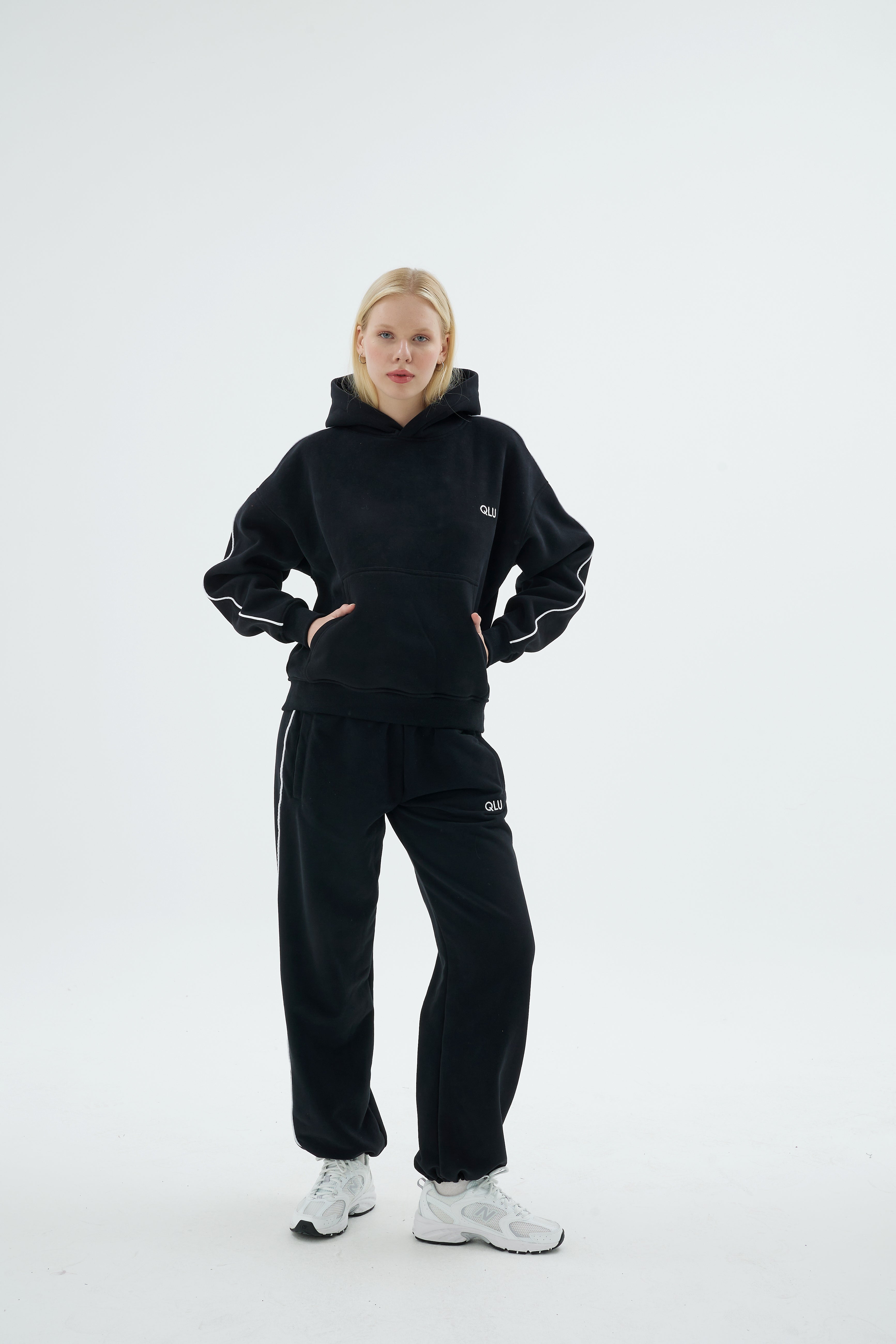 Siyah QLU Rise Line hoodie ve Line jogger eşofman takımı giymiş kadın