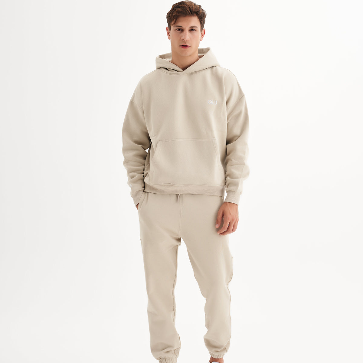 qlu bej bir sweatshirt ve eşofman giyen bir adam