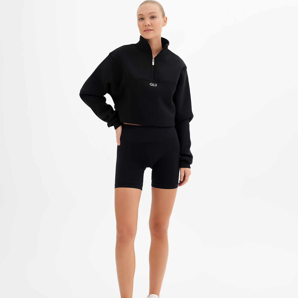 qlu siyah bir sweatshirt ve şort giyen bir kadın