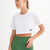 qlu bir kadın beyaz bir crop top ve yeşil tayt giymiş